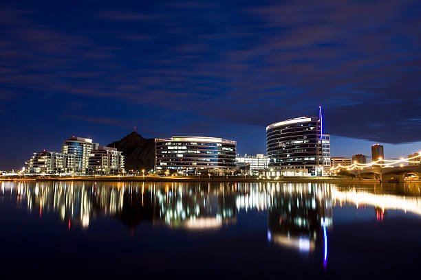 Tempe, Arizona downtown with lights Tempe Town Lake with a bridge and the Tempe Downtown skyline in the background.  tempe arizona stock pictures, royalty-free photos & images