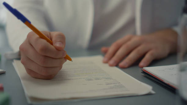 istock Doctor hands writing medical documents close up. Unknown medic filling journal. 1469047576