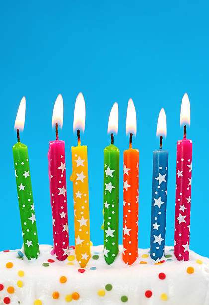 istock Brightly colored lit birthday candles with stars on in cake 146904992