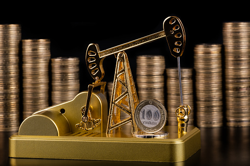 Oil pump made of gold and columns of Kazakhstani coins in denominations of 100 tenge