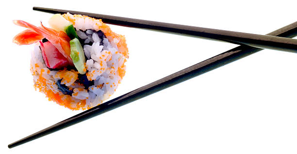 Sushi Between Black Chopsticks Isolated on White Background stock photo