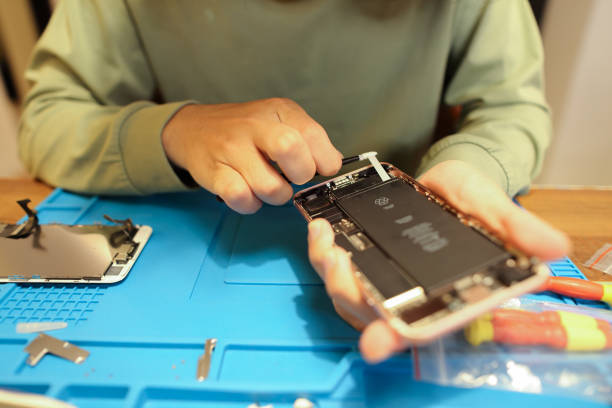 adolescente asiatico che ripara il telefono cellulare - battery replacement foto e immagini stock