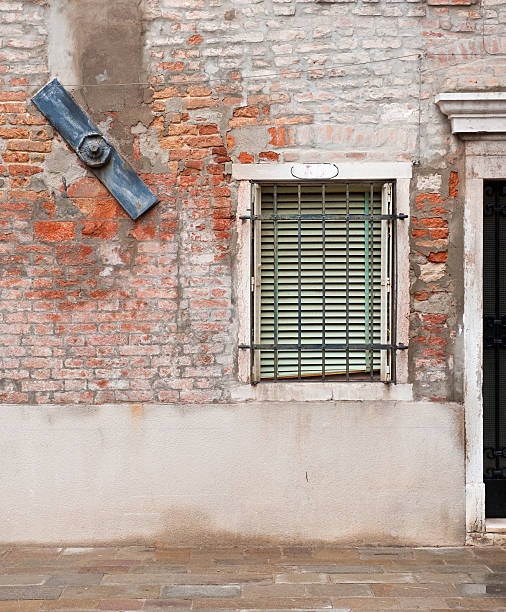 Brick wal,  brace and window with bars.  Venice, Italy stock photo