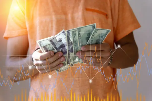 A man holds dollars in his hands. Price growth chart, investments, cryptocurrency, new money, income