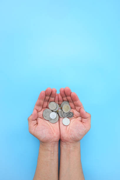 istock Two hand holding money coin on blue background 1469073138