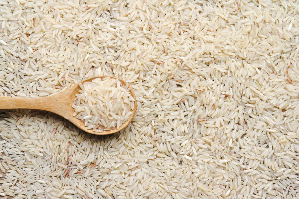 istock Organic raw rice in wooden spoon with rice background 1469073166