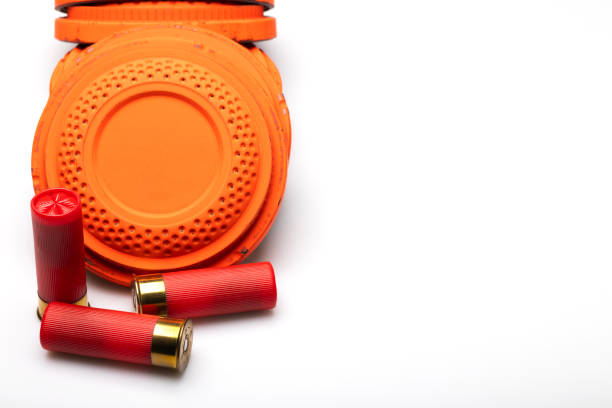 istock Stack of Clay shooting target with red shotgun shell bullets on white background 1469074028