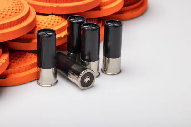 istock Black shotgun shell bullets with clay shooting target on white background 1469074542