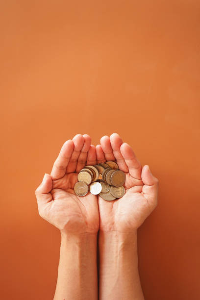 istock Two hand holding money coin on brown background with copy space 1469075350