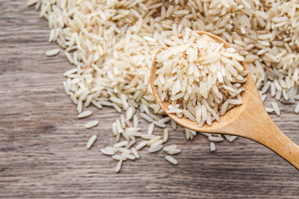 istock Organic raw rice in wooden spoon with rice background 1469075361