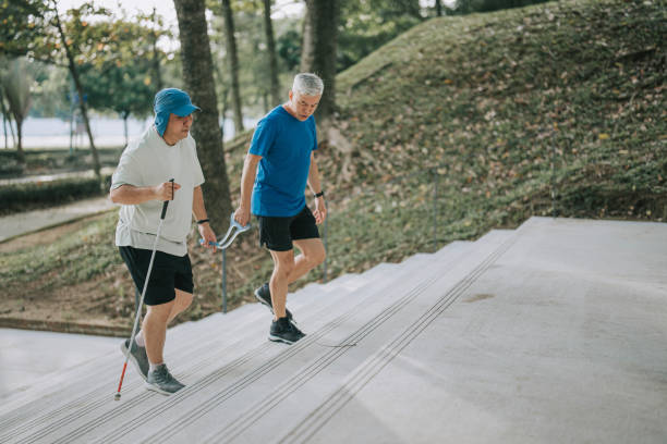 azjatycki chiński przewodnik biegacz i niedowidzący dojrzały mężczyzna uprawiający jogging w parku w weekendowy poranek - blind trust zdjęcia i obrazy z banku zdjęć