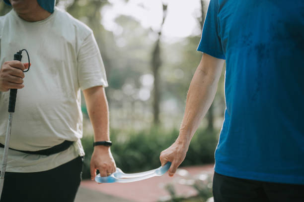 istock Close up Asian Chinese visually impaired mature man holding running  tether in public park with guide runner 1469076854