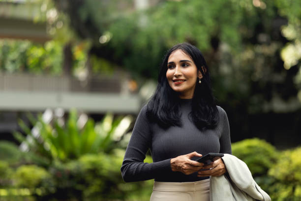 Indian businesswoman walking and using her mobile phone