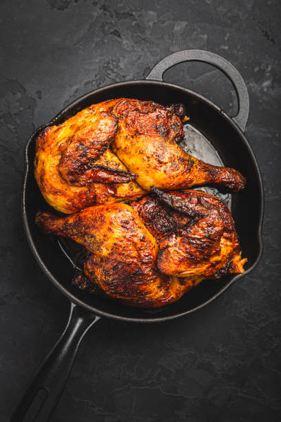 istock Roasted half chicken in pan on black background 1469085412