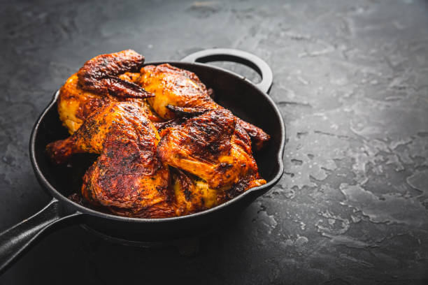 istock Roasted half chicken in pan on black background 1469085418