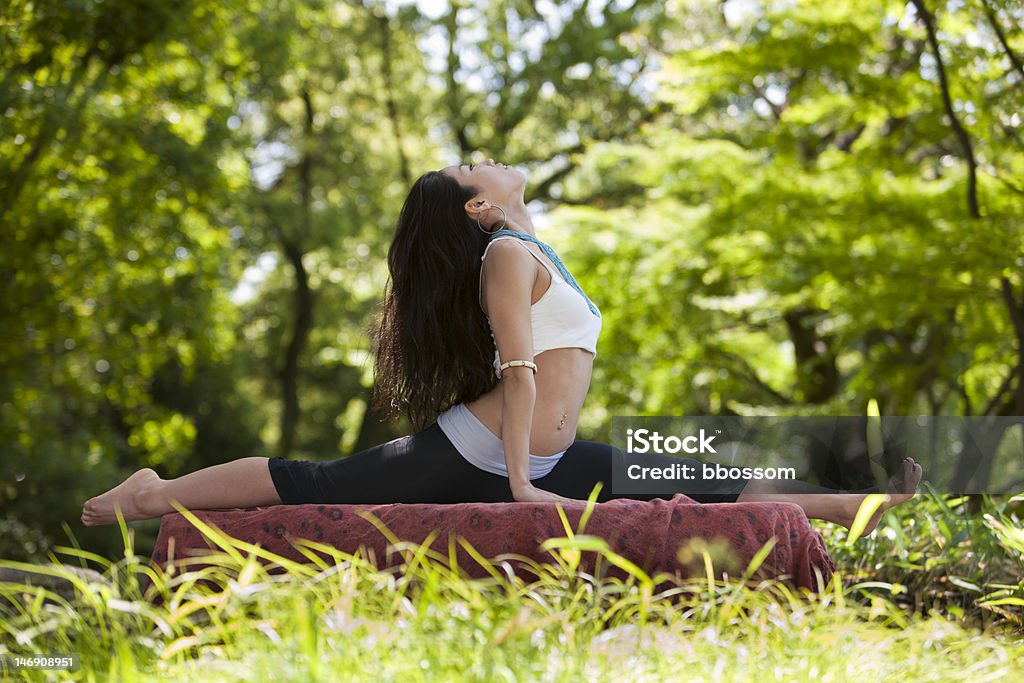 Japonés mujer mira mientras que haciendo yoga pose - Foto de stock de 20 a 29 años libre de derechos