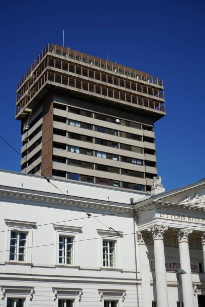 istock a tall building with some windows, two columns and a red bus on the road 1469090116