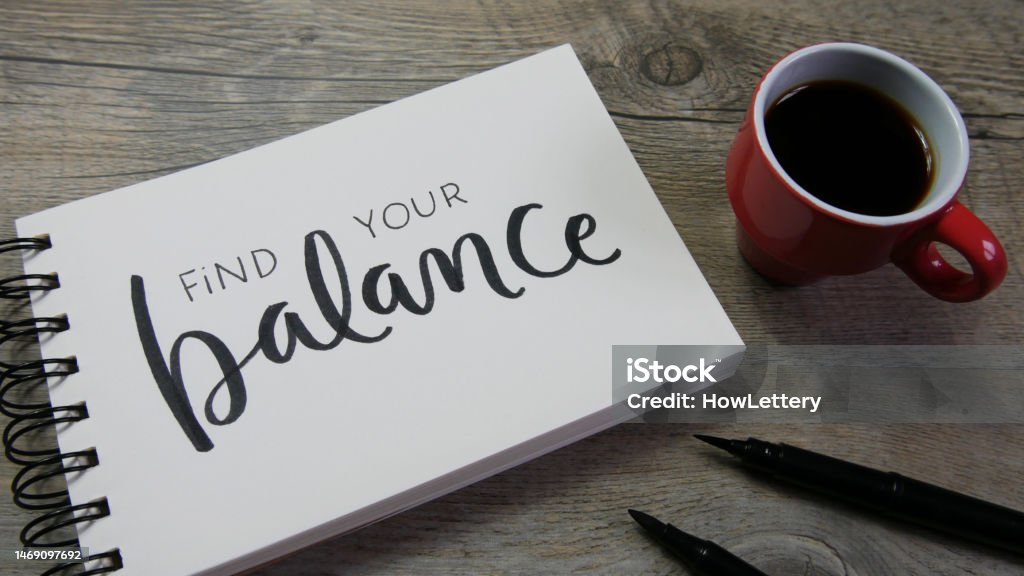 FIND YOUR BALANCE lettering in notebook FIND YOUR BALANCE lettering in notebook with cup of coffee and pens Menopause Stock Photo