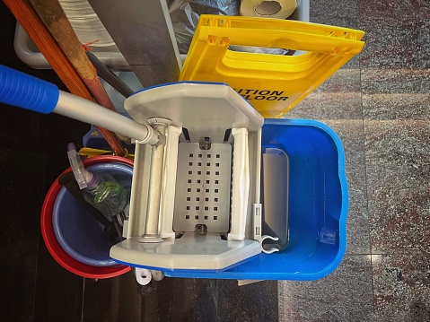 Overhead view of floor mopping rinse bucket and cleaning tools