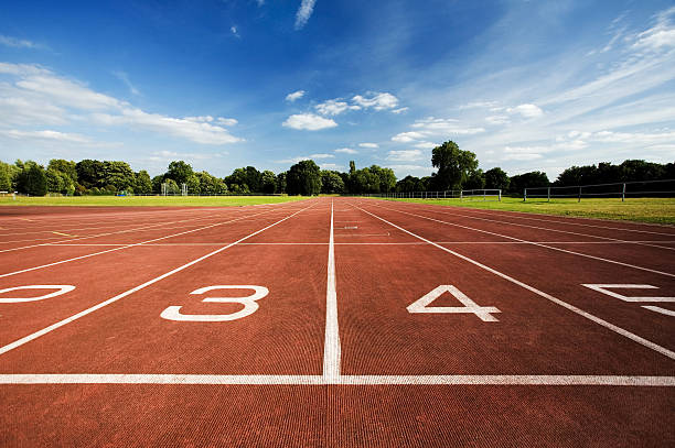 View of running track surrounded by a forest on a clear day stock photo