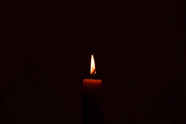 istock One light candle burning brightly in the dark background.Copy space. 1469107842
