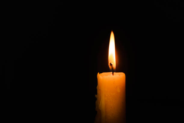 istock One light candle burning brightly in the dark background.Copy space. 1469107864
