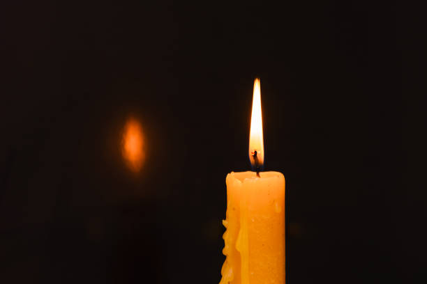 istock One light candle burning brightly in the dark background.Copy space. 1469107888