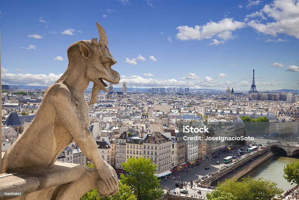 Notre Dame: Chimera (demon) overlooking Paris skyline a summer day Can see the Eiffel tower and the river Seine. Gargoyle Stock Photo