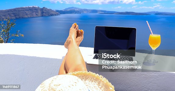 istock Digital nomad freelancer woman  lying and sunbathing as  remotely with bright scenic view of the Mediterranean Sea ,Oia -Santorini,Greece 1469111867