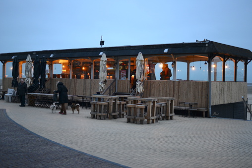 Bruges at sea, West-Flanders, Belgium - February 21, 2023: only one side walk cafe is open on Crocus winter holidays. Zeebrugge has a very short beach area, low number residents and tourists