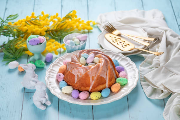 istock Easter cake with glaze icing decoration and colored easter eggs on blue wooden table 1469117867