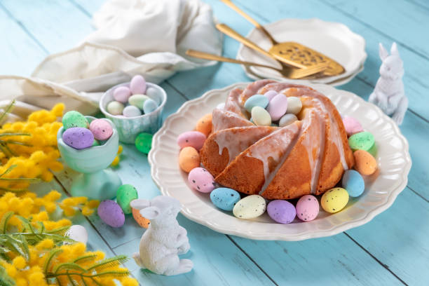 istock Easter cake with glaze icing decoration and colored easter eggs on blue wooden table 1469117870