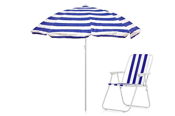 A view of a blue and white striped umbrella and beach chair isolated on white background