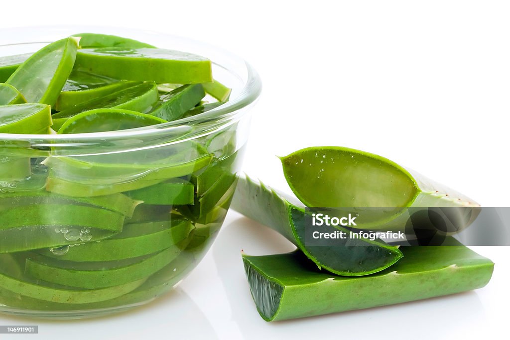 Sliced Aloe Vera plant Fresh green slices of aloe vera plant soaking in water, on white studio background Aloe Stock Photo