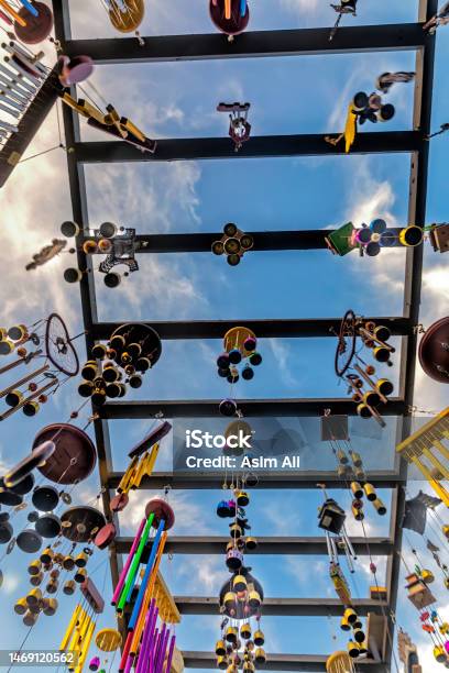 Wind Chimes Of Deferent Pattern Material And Designs Hanging High Up On A Wooden Structure Stock Photo - Download Image Now