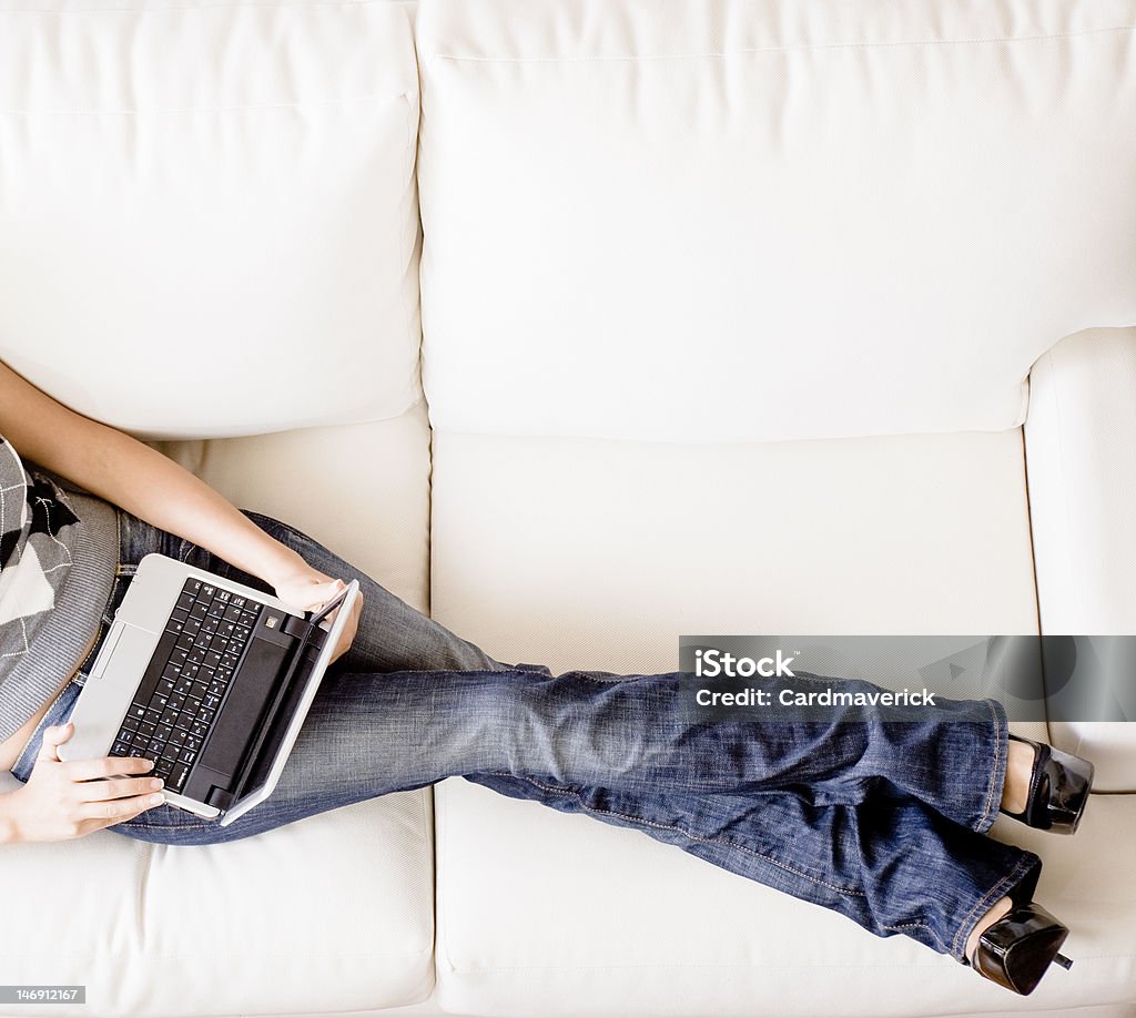 Vista aérea de la mujer en sofá con el ordenador portátil - Foto de stock de 20 a 29 años libre de derechos