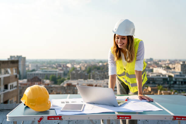 istock Young female construction specialist engineer reviewing blueprints at construction site 1469123690