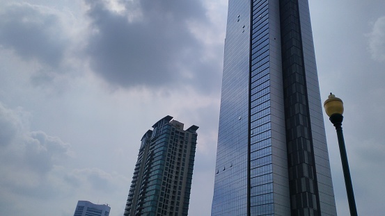 a photo of a skyscraper against a slightly cloudy sky in the background