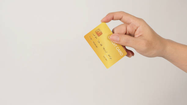 istock Hand is holding gold credit card isolated on white background. 1469124357