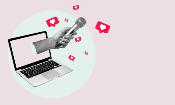 istock Collage art, a hand with a microphone protruding from a laptop against a pink background. 1469125532