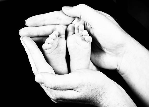 istock baby feet held inside mothers hands 146912613