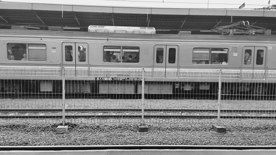 black and white photo of railroad tracks and electric train cars parked at Tanah Abang Station Jakarta Indonesia, November 3, 2022