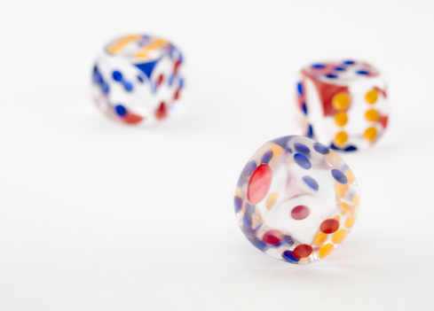 A spinning dice against a background of two other thrown dice