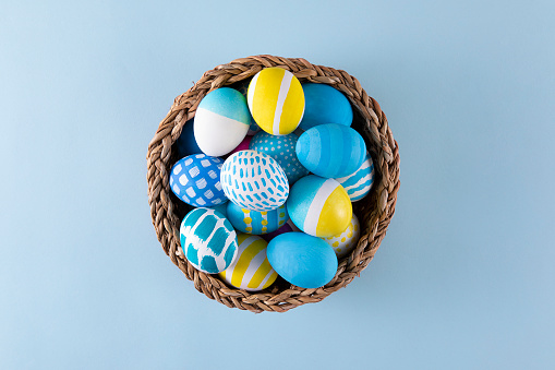 Easter eggs in a basket on blue background