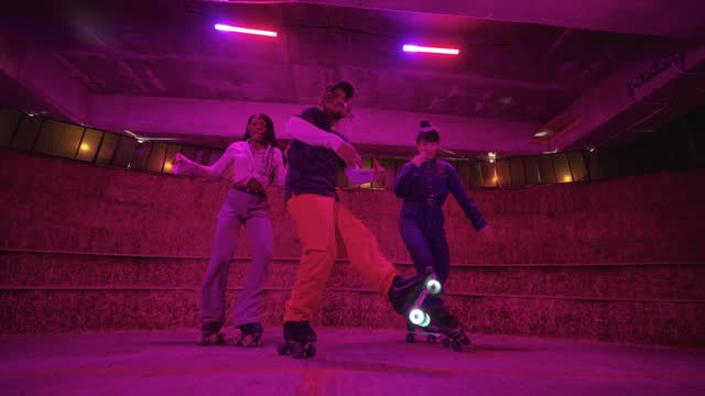 Freestyle roller skaters under neon lighting