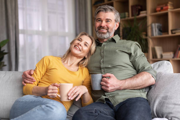 istock Middle Aged Couple Spending Time At Home, Drinking Coffee And Watching Tv 1469136585