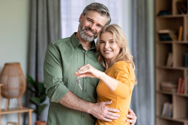 istock Happy middle aged couple holding home keys and smiling 1469136826