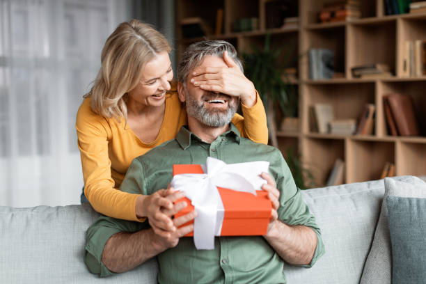 istock Loving Wife Surprising Middle Aged Husband With Present At Home 1469136847