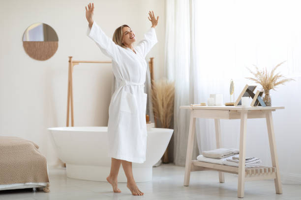 istock Joyful middle aged lady dancing by white bathroom at home 1469137101