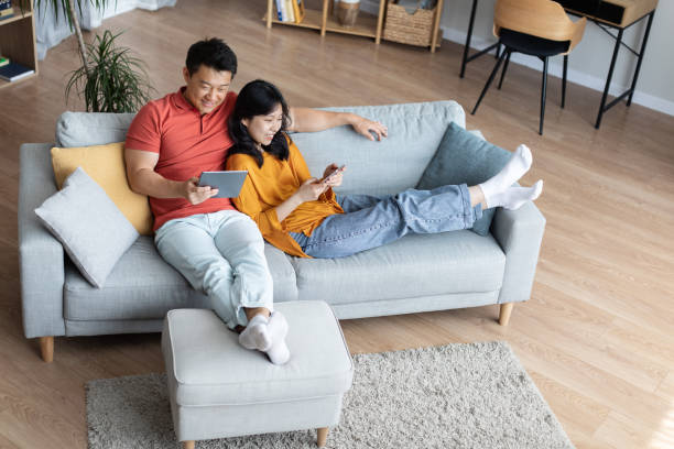 istock Top view of couple chilling together at home, using gadgets 1469137145